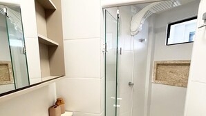 A modern bathroom with a glass-enclosed shower, a vanity with a mirror, and a toilet. - Dutra Ocean Flat By DayByDay (Joao Pessoa)