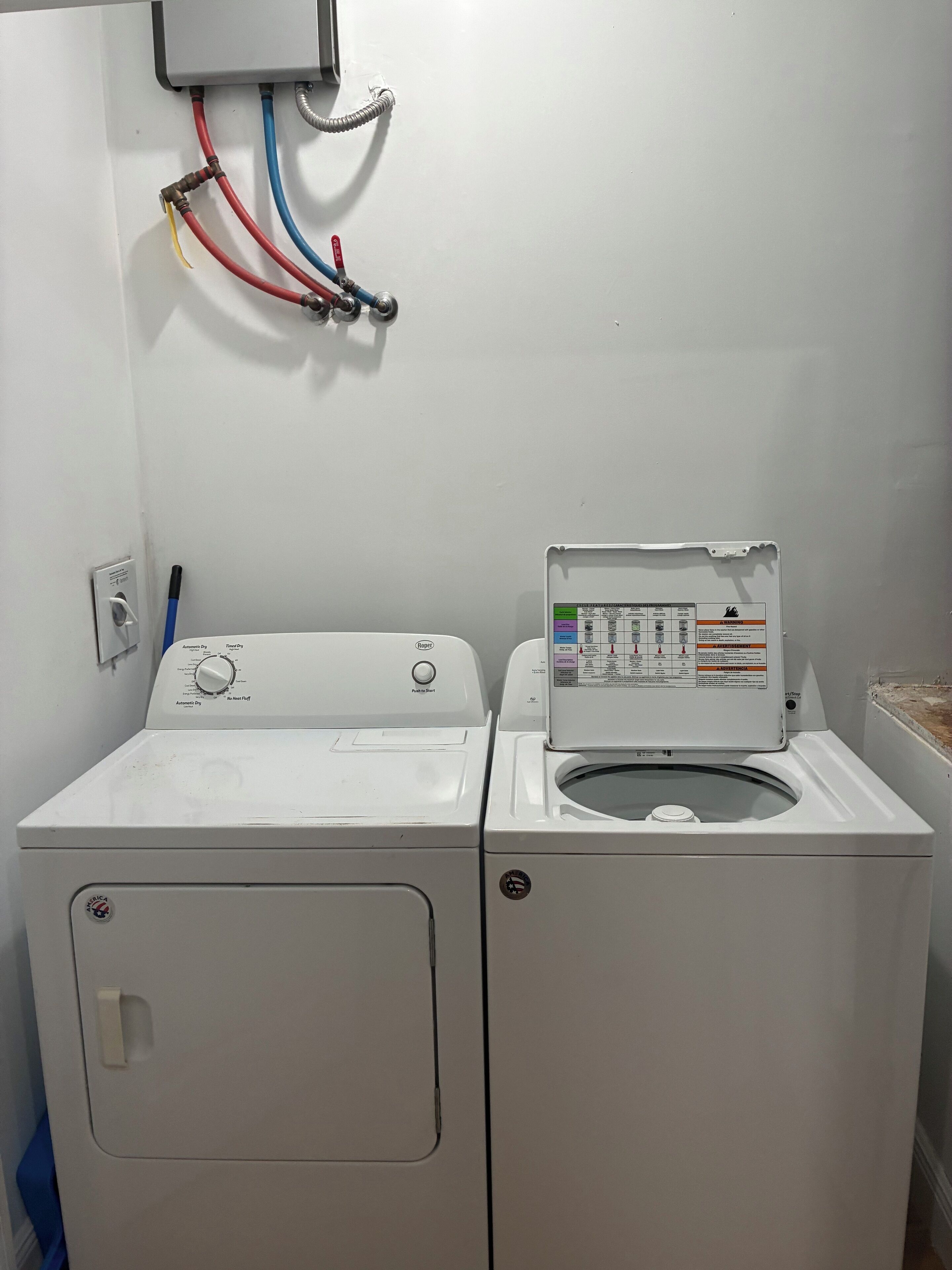 A front-loading washer and dryer unit with a control panel and a power outlet with multiple cables.