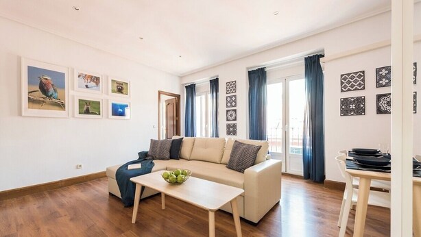 Ein modernes Wohnzimmer mit Sofa, Couchtisch und Essbereich.