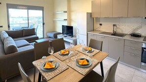 A modern apartment with a dining area, kitchen, and living room. - Cozy Modern Apartment with Sea View (Sarandë)