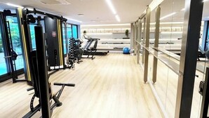 A modern gym with exercise equipment, a treadmill, and a blue exercise ball. - Csq Jardins By DayByDay (Joao Pessoa)