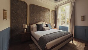 Ein Schlafzimmer mit einem großen Bett, zwei Nachttischen mit Lampen, einem Fenster mit Vorhängen und einer dekorativen Deckenleuchte.