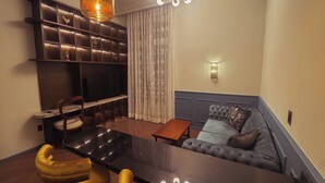 Ein modernes Wohnzimmer mit einer Couch, einem Esstisch und einem Fernseher.
