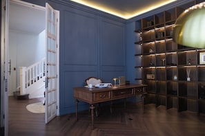 Une pièce avec un bureau, une porte ouverte et une bibliothèque.