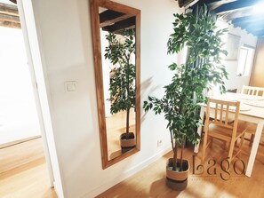 A room with a wooden dining table, chairs, a potted plant, and a mirror with a wooden frame. - Apartment for Groups and Families in SOL (Centre)   (Madrid)