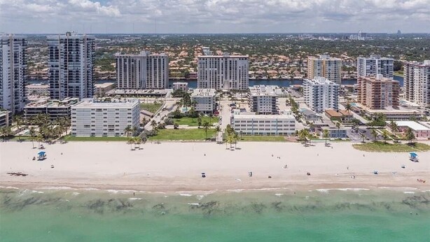 Un paysage urbain c ôtier avec de hauts immeubles, une plage de sable et un ciel dégagé.