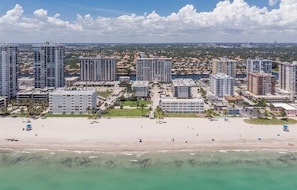 A coastal cityscape with high-rise buildings, a sandy beach, and a clear sky. - Beach Front Bliss in Hollywood (Hollywood)