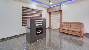 A reception area with a modern desk, a ceiling fan, and a leather sofa.