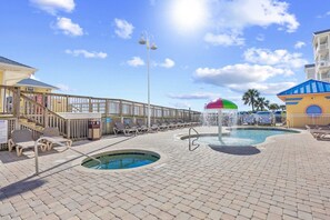 A pool area with lounge chairs, a small pool, and a covered seating area. - 2/2 condo at Cherry Grove Pier (North Myrtle Beach)