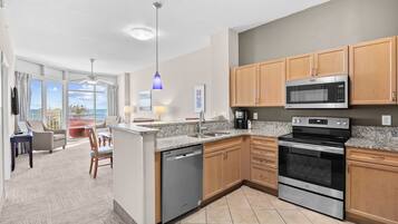 A modern kitchen with granite countertops, stainless steel appliances, and wooden cabinets.