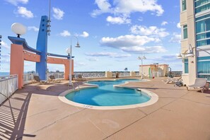 Ein Poolbereich mit Liegestühlen und Meerblick.