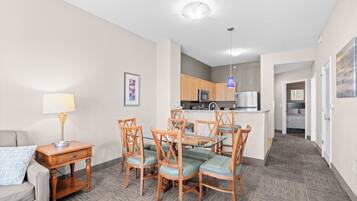 A compact living space with a dining area, kitchenette, and a small bedroom.