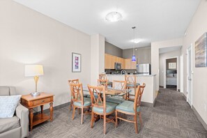 A compact living space with a dining area, kitchenette, and a small bedroom.