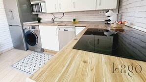 Eine moderne Küche mit weißen Schränken, einem Einbauofen, einer Mikrowelle und einem Geschirrspüler.