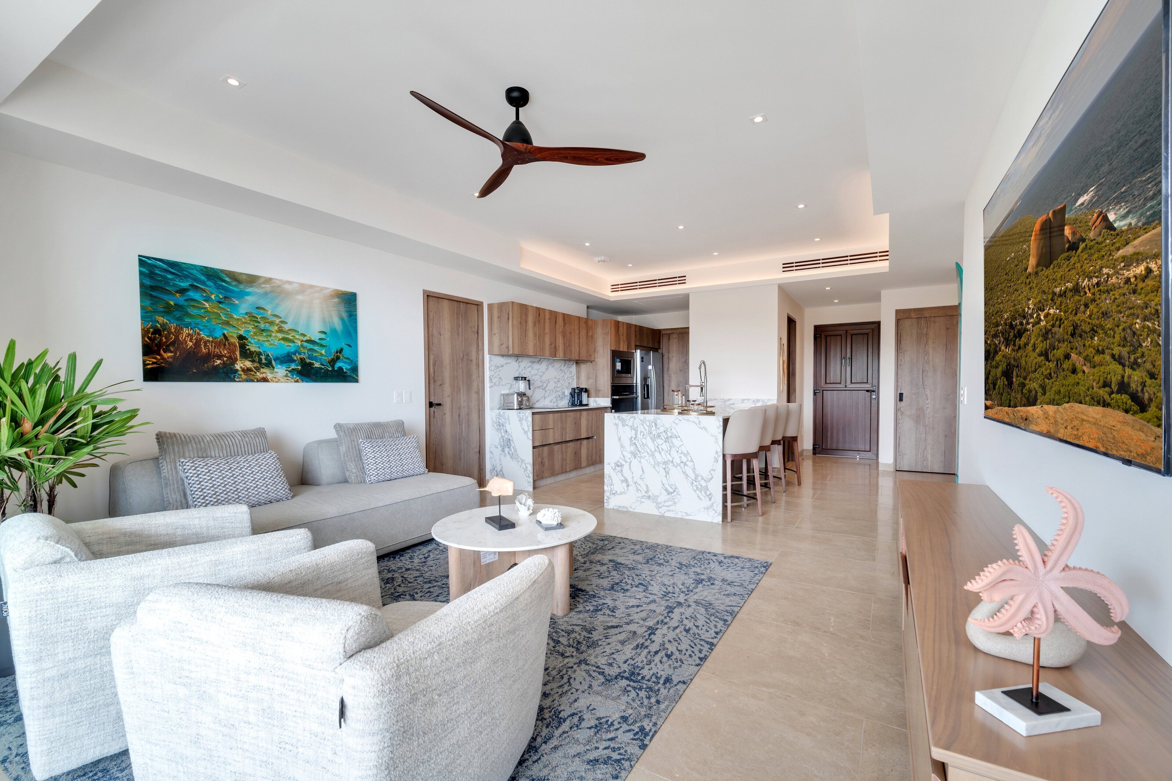 Un salon moderne avec un canapé, une table basse et un tableau représentant une scène sous-marine.
