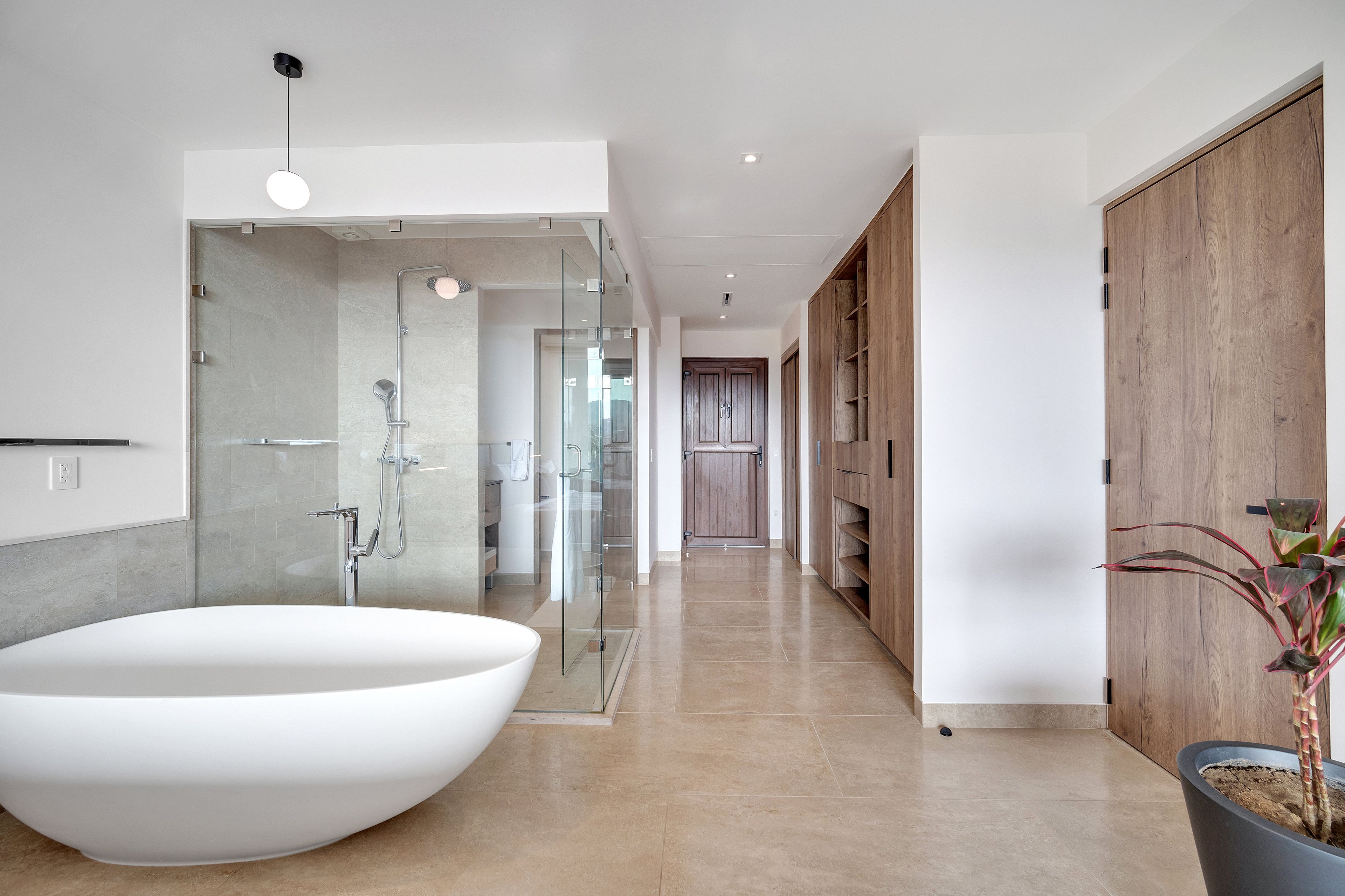 Un baño moderno con bañera independiente, cabina de ducha de vidrio y muebles de madera.