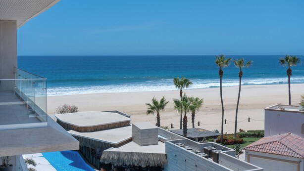 A beachfront property with a pool, a balcony with glass railings, and a view of the ocean. - Albaluz (San Jose del Cabo)