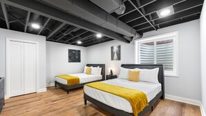 A hotel room with two beds, wooden flooring, a white door, and a window with blinds. - Elgin Escape –Near Train, Parks & Restaurants (Elgin)