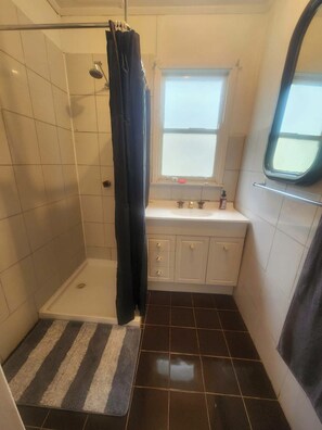 Chuveiro, toalhas de banho, sabonete, papel higiênico