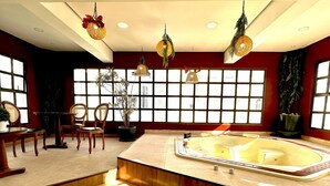A modern bathroom with a large bathtub, wooden chairs, a small table, and large windows with a view. - Executive apartment on Paulista Avenue – across from Rosewood and Soho House SP (São Paulo)