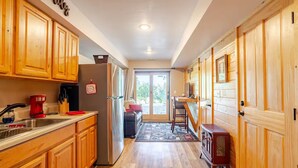 A kitchen with wooden cabinets, a stainless steel refrigerator, and a red coffee maker. - Lower Cozy Cabin in Powderhorn Ski Resort (Mesa)