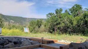 A stone pathway leading to a wooden deck with a sign in the background. - Lower Cozy Cabin in Powderhorn Ski Resort (Mesa)
