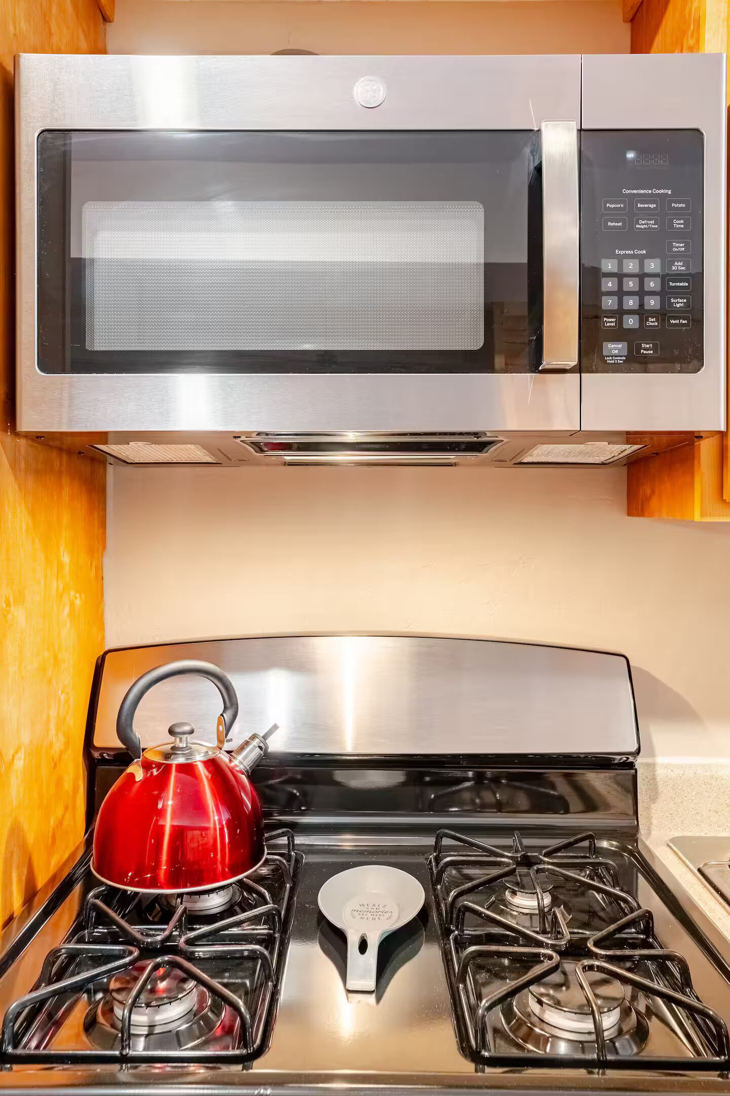 A kitchen with a stainless steel microwave and stove.
