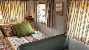 Un interior acogedor con una cama, un sofá verde y una mesa.
