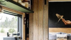 A cozy bedroom with a bed, a coffee table, and a window.