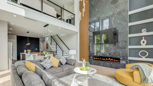 A spacious living area with a sectional sofa, a yellow armchair, and a fireplace. - Luxury Newly Built 4 BR 4 Bath Home w/ Rooftop and Grill! (Dallas)