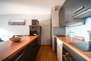 Eine moderne Küche mit Holzarbeitsplatten, Edelstahlgeräten und Blick ins Freie.
