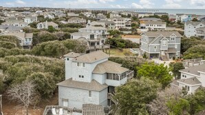 A residential area with houses, a beach, and a pier in the background. - 3946 - Summers by the Sea - Duck OBX Retreat w/ Pool & Hot Tub Near Beach (Duck)