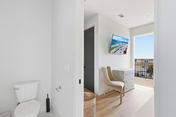 Une salle de bain moderne avec des toilettes, un panier en osier et un lavabo blanc.