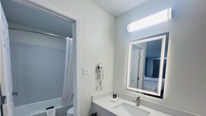 A bathroom with a shower, toilet, and sink.