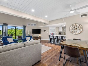 A modern living room with a sofa, a dining table, and a kitchen area. - Spacious 3BR villa in South Forest Beach, Hilton Head Island, perfect for families. (Hilton Head Island)