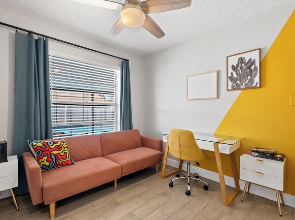 A modern living room with a sofa, a desk, and a chair.