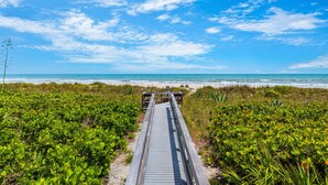 A wooden boardwalk leading to a beach with clear skies and ocean views. - Luxurious Penthouse W/ Direct Ocean Front  Balcony, Heated Pool & Hot Tub!  🌊 (Cape Canaveral)