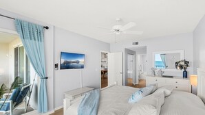 A bedroom with a bed, a ceiling fan, a TV, a desk, and a chair. - Luxurious Penthouse W/ Direct Ocean Front  Balcony, Heated Pool & Hot Tub!  🌊 (Cape Canaveral)