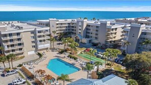 Un hotel con varias edificaciones, piscina y vista al océano.