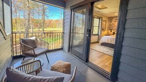 A balcony with wicker furniture and a view of a golf course. - Luxury + Close to slopes + Golf Side (McHenry)