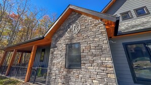A stone building with a wooden porch and a large window. - Luxury + Close to slopes + Golf Side (McHenry)