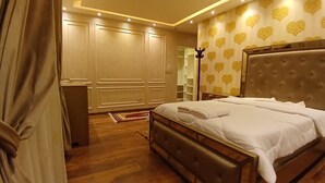A bedroom with a large bed, a wardrobe, and a mirror. - Alsawah 3BR Duplex with garden in Eastown sodic (New Cairo)