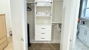 A walk-in closet with multiple shelves, drawers, and hanging space. - Excellent Place to Stay (Coquitlam)