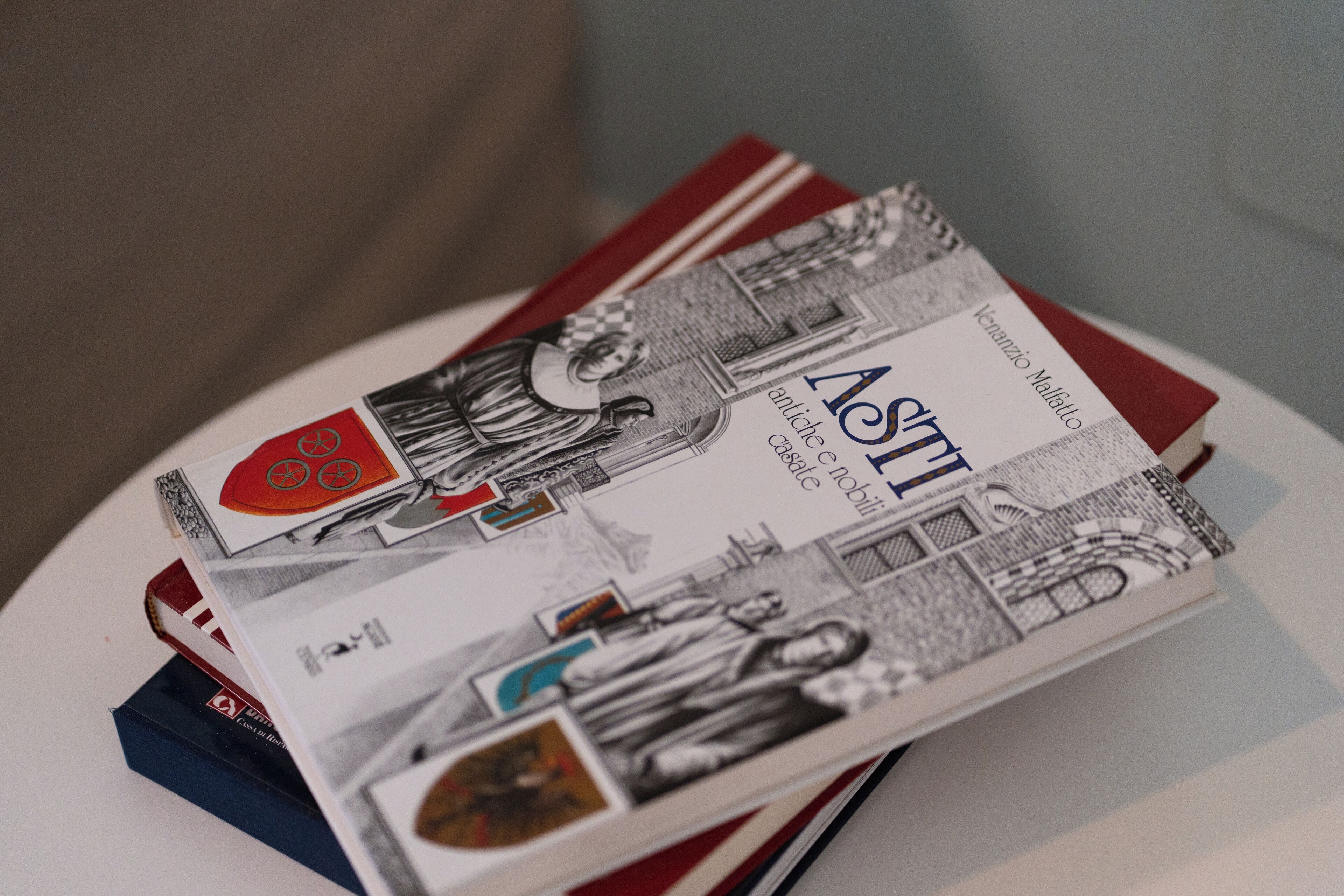 A stack of books with illustrations and text, placed on a white surface.