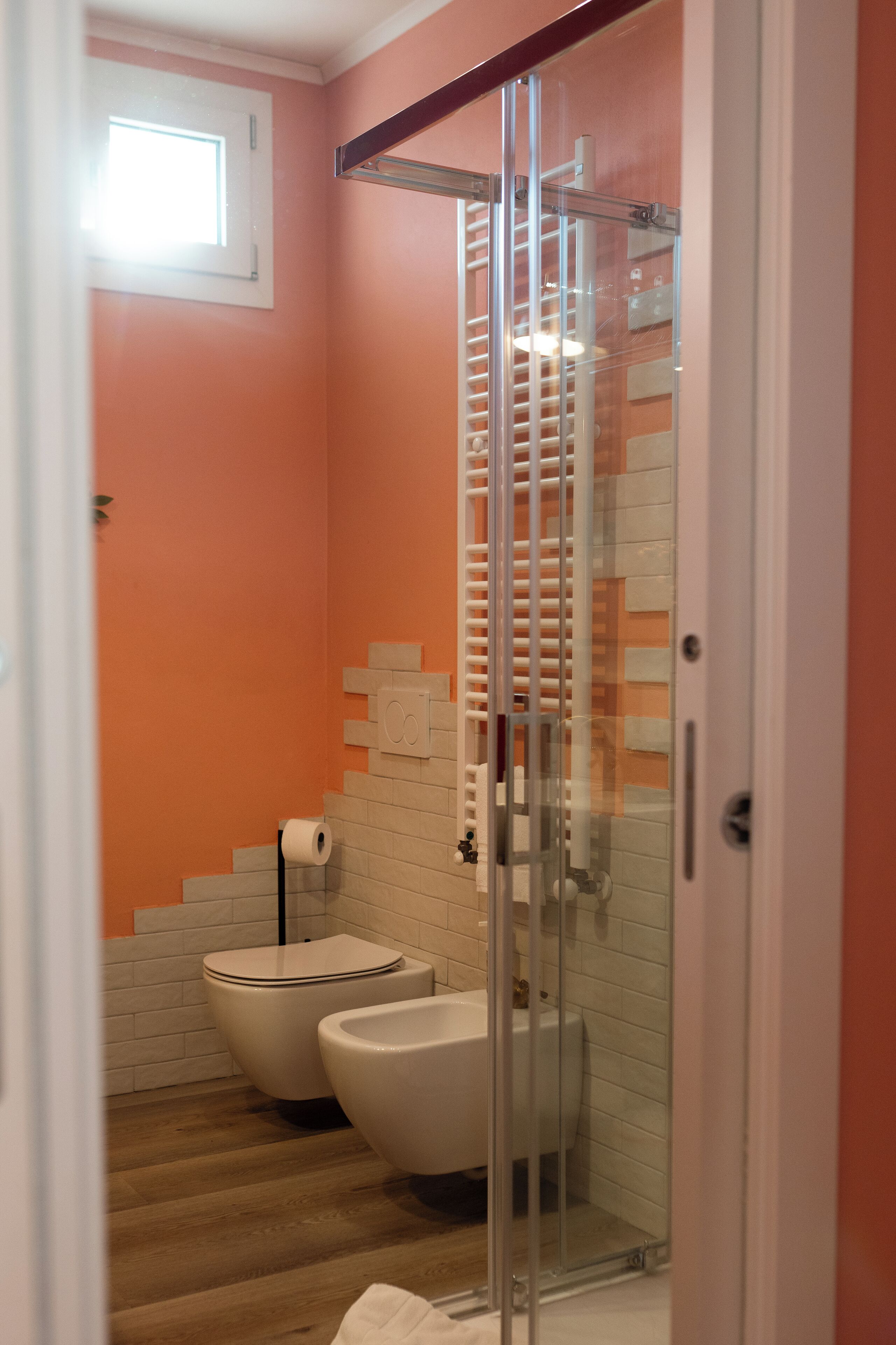 Ein Badezimmer mit Duschkabine aus Glas, Toilette und Bidet.