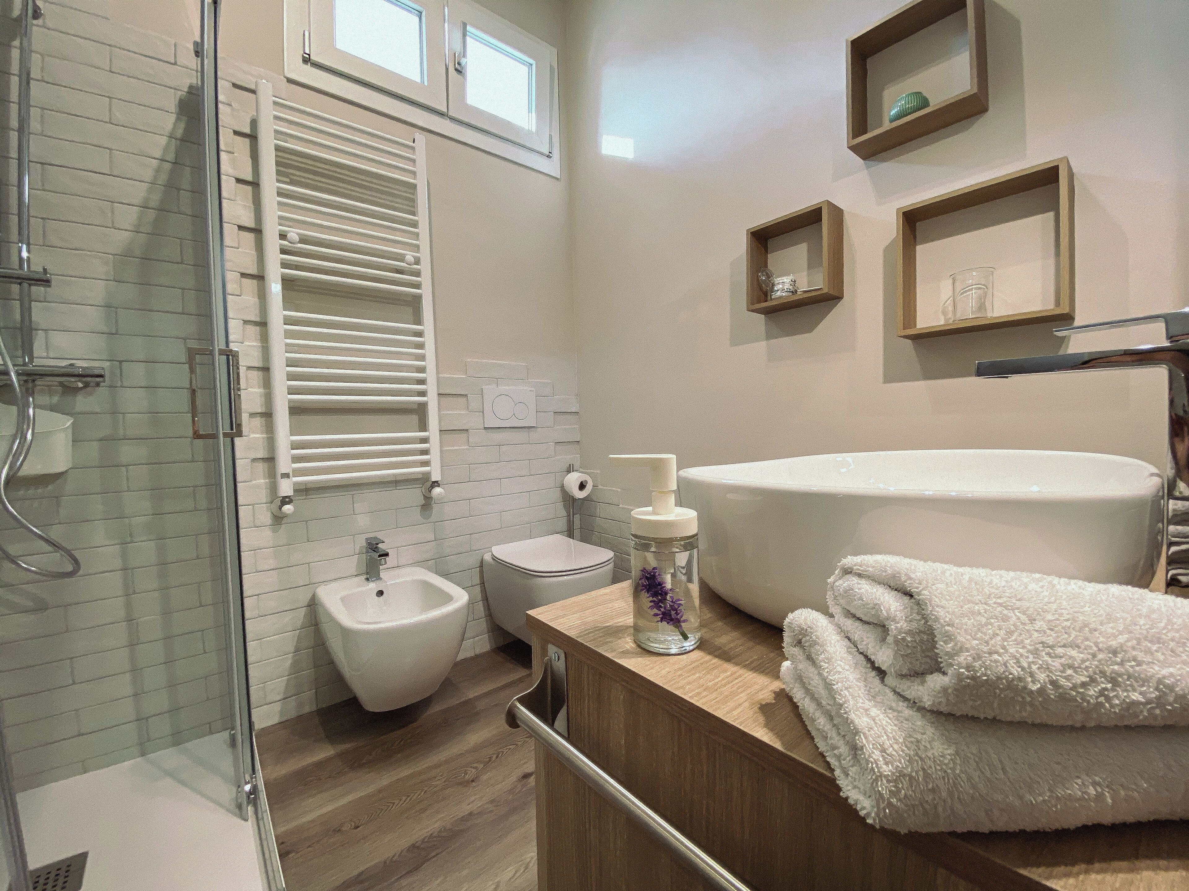 A modern bathroom with a bidet, toilet, and a large bathtub.