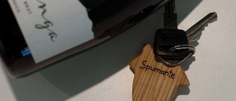 A bottle of wine with a wooden keychain labeled "Spumante" and a label that reads "Alba Langa."