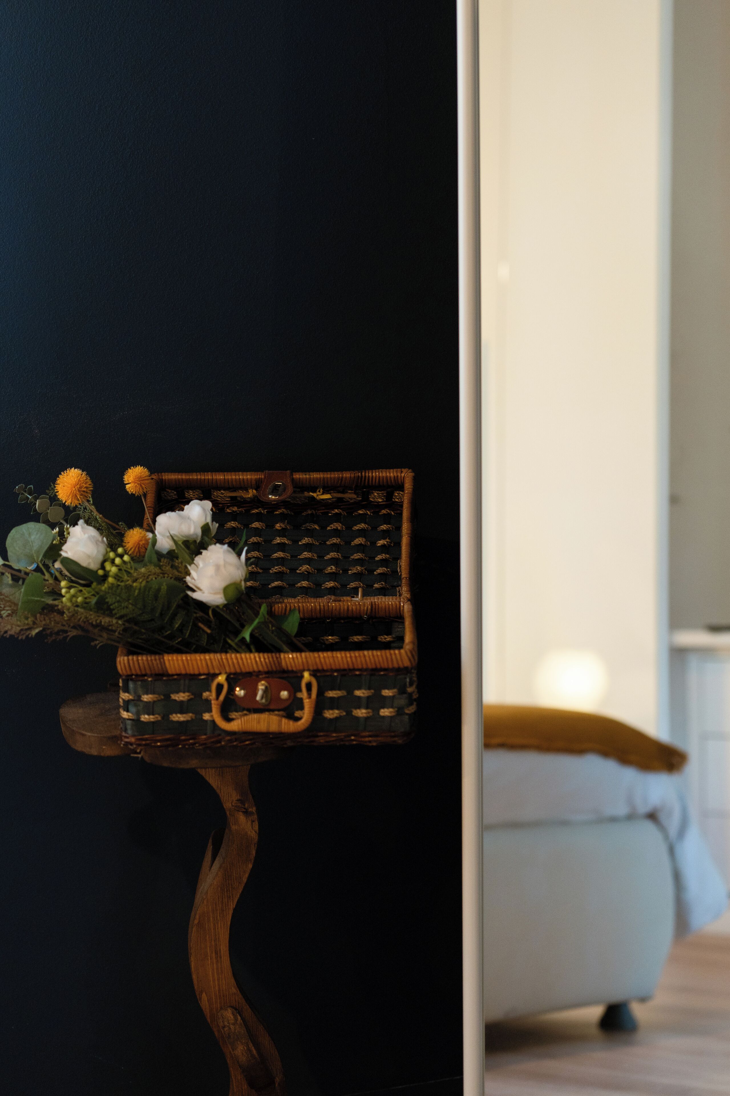 Una cesta de mimbre con flores sobre un soporte de madera.