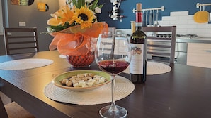 A dining table with a wine glass, a bottle of wine, and a bowl of snacks. - WellHome Asti (Asti)
