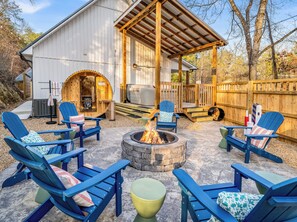An outdoor seating area with Adirondack chairs, a fire pit, and a sauna. - Dragonfly Grove ~ Hot Tub, Sauna, Outdoor Movies (Pigeon Forge)
